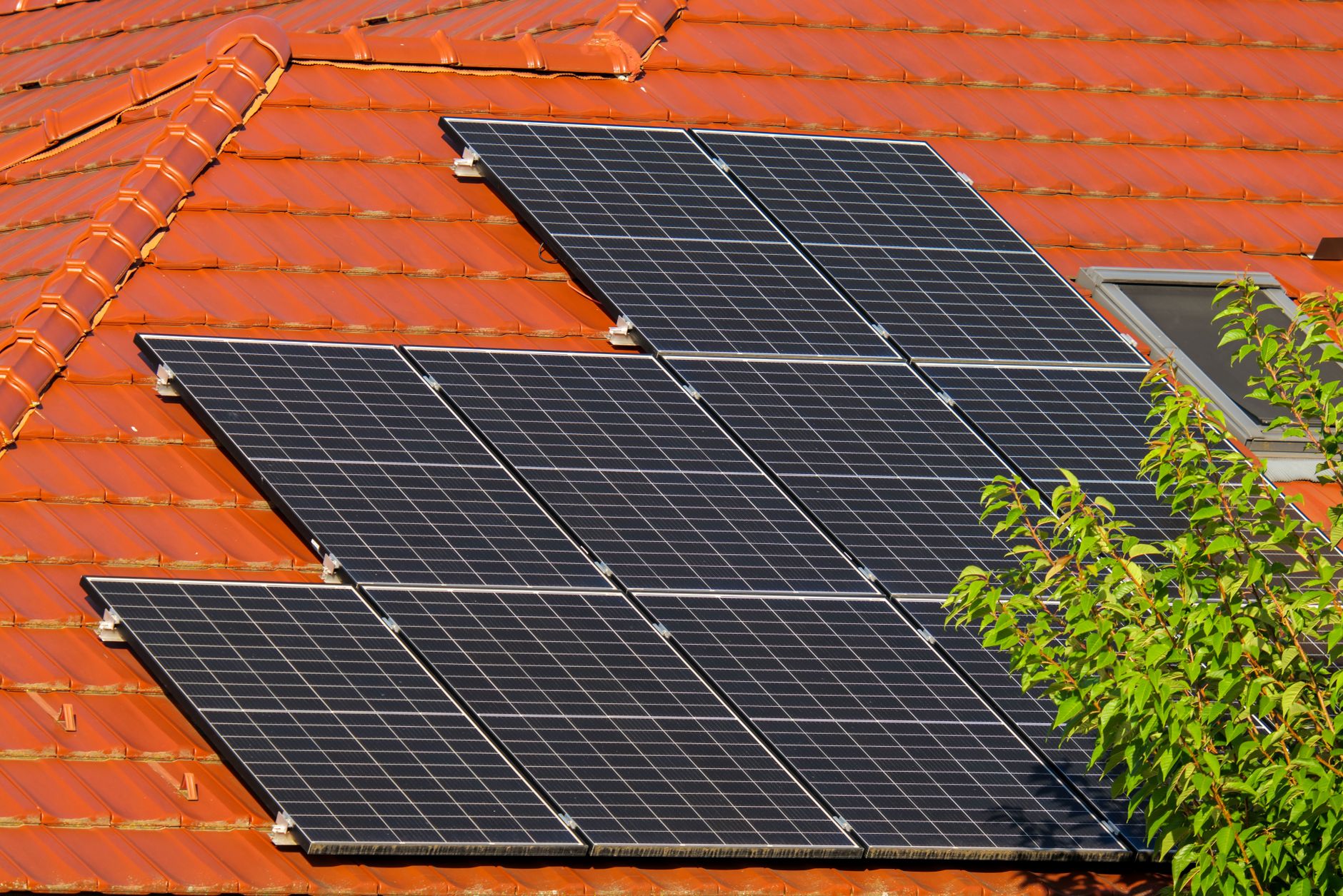 Black rigid solar panel bolted to an RV roof with cable