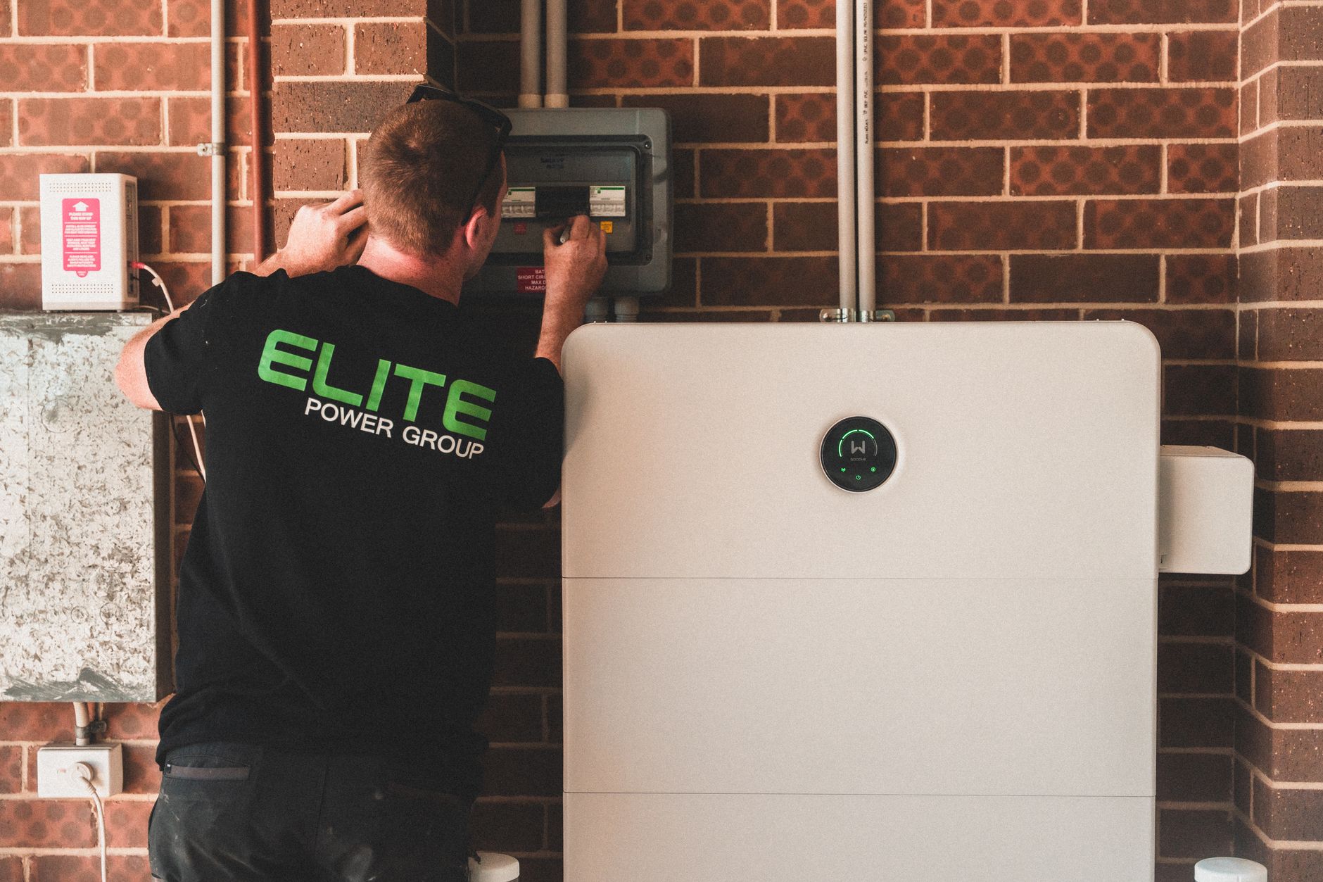 a wall-mounted home battery system in a clean concrete garage with clearance around it
