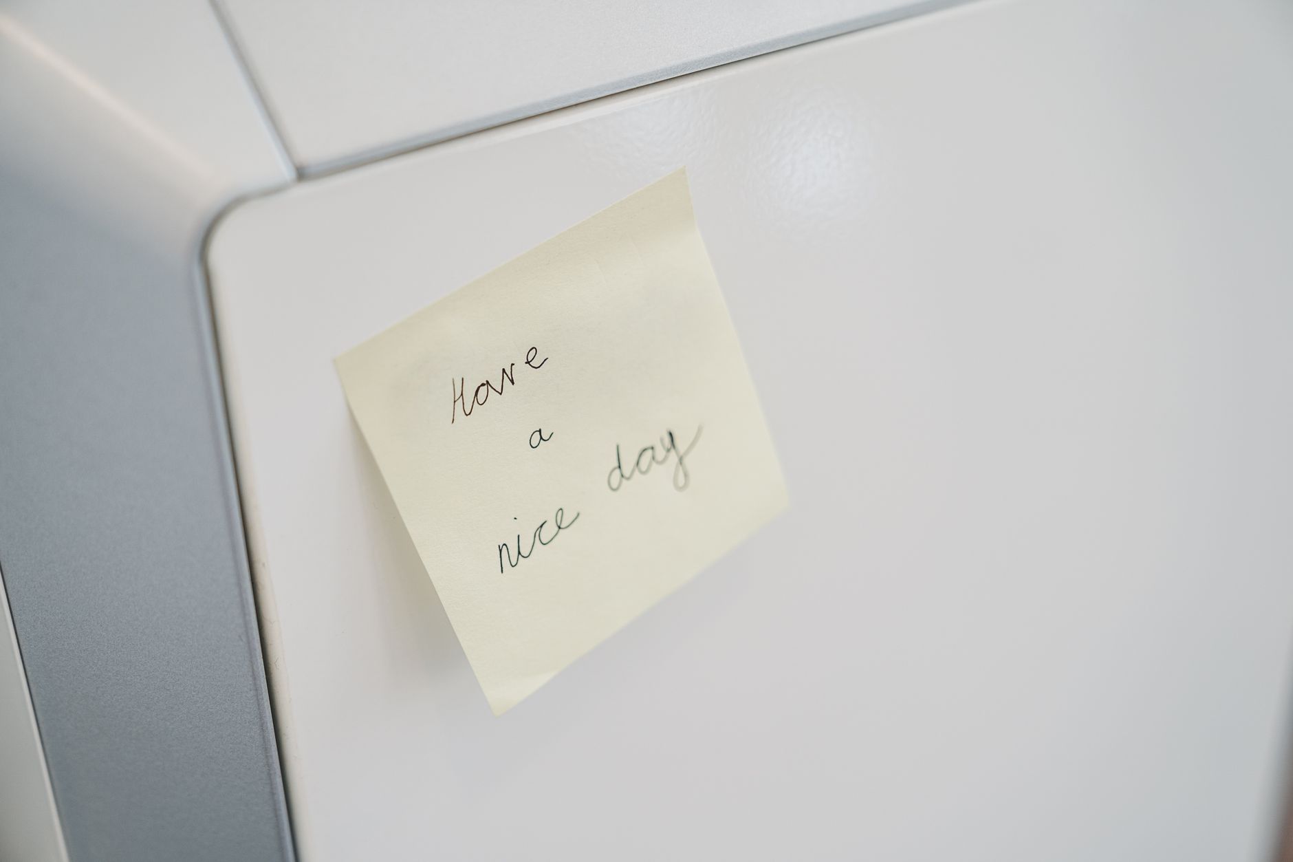 A closed refrigerator door with a handwritten outage time note taped to it
