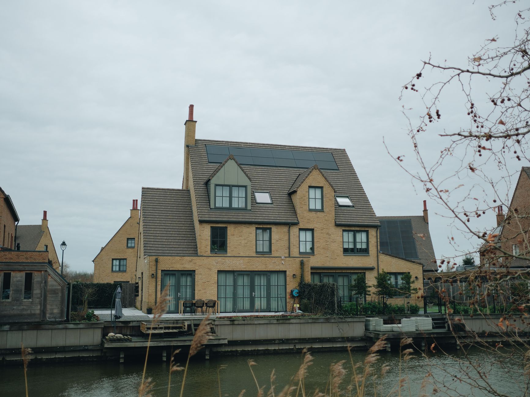 A modern Ontario home with rooftop solar panels and a battery storage unit outside